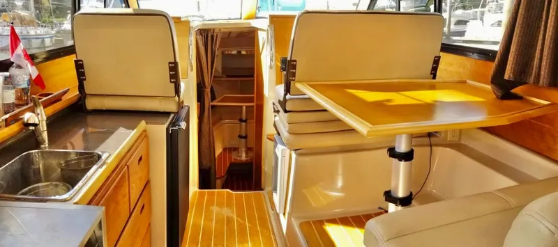 Denial Yacht Photos Pics Interior of 2012 Cutwater C-28 boat with seating, table, and kitchenette.