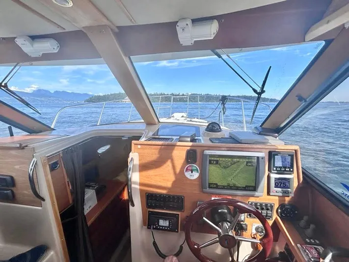 Denial Yacht Photos Pics Interior view of 2012 Cutwater C-28 boat cockpit with navigation equipment and scenic ocean backdrop.