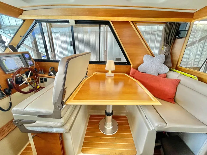 Denial Yacht Photos Pics Interior of 2012 Cutwater C-28 boat with wooden table, seating, and helm station.