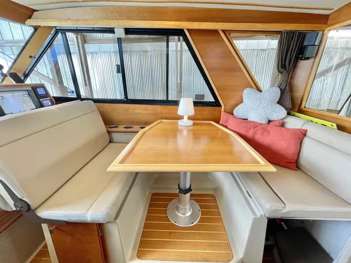 Denial Yacht Photos Pics Interior of 2012 Cutwater C-28 boat with cozy seating and wooden table.