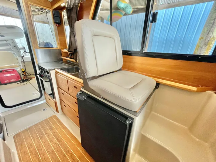 Denial Yacht Photos Pics Interior of 2012 Cutwater C-28 boat with seating, kitchenette, and wood accents.