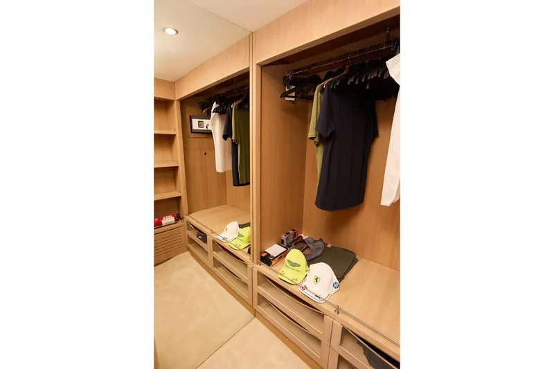 Pobedy I Yacht Photos Pics Luxurious wooden closet interior on a 2004 Maiora 26.5 yacht, featuring clothing and accessories.