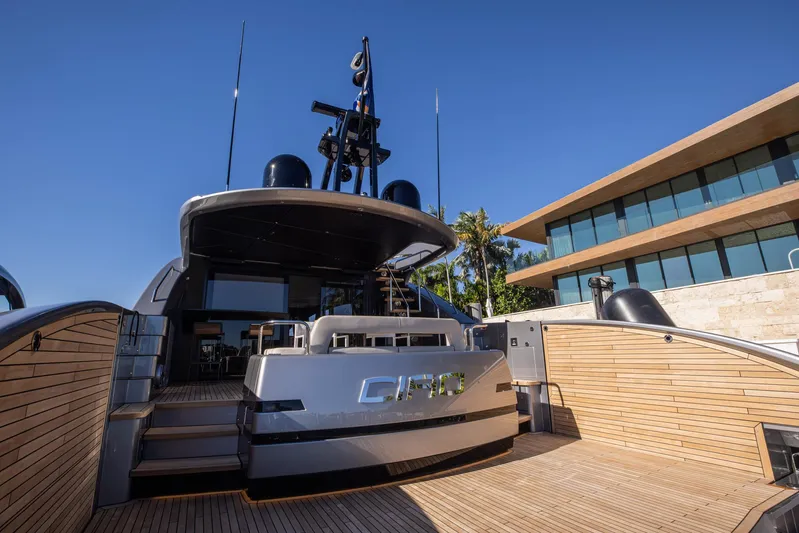  Yacht Photos Pics 2025 Pershing GTX80 yacht docked, showcasing sleek design and modern architecture in the background.