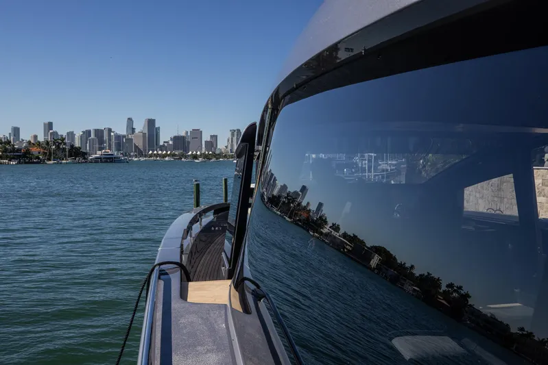  Yacht Photos Pics 2025 Pershing GTX80 yacht with city skyline reflection on water.