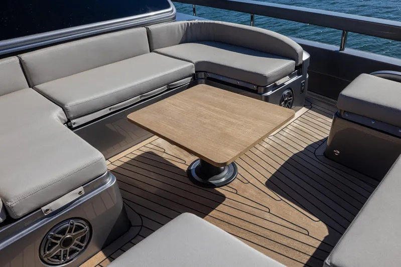  Yacht Photos Pics Luxurious seating area on 2025 Pershing GTX 80 yacht with wooden table and cushioned seats.