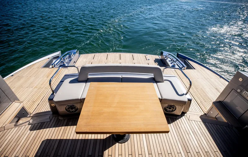  Yacht Photos Pics Luxury deck of 2025 Pershing GTX80 yacht with wooden table and seating.