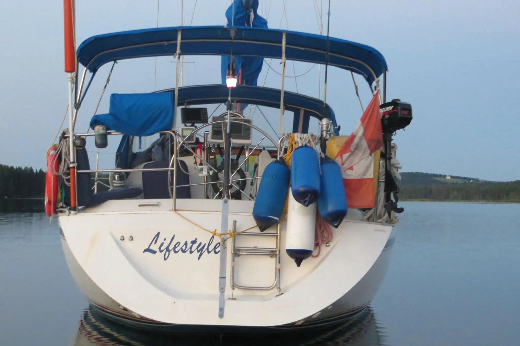 Sailboat "Lifestyle" on calm water, CS 34 model, 1990, with blue canopy and fenders.
