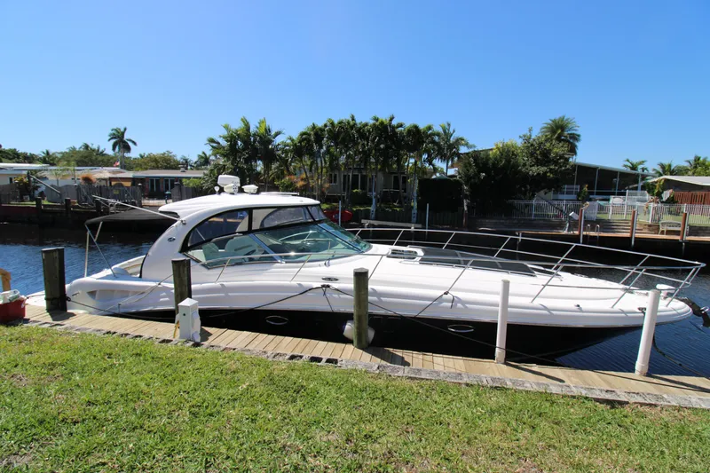 Rowdy Rio Yacht Photos Pics 2008 Sea Ray 44 Sundancer yacht docked by a canal, surrounded by lush greenery.
