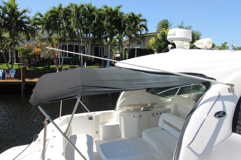 Rowdy Rio Yacht Photos Pics 2008 Sea Ray 44 Sundancer yacht with canopy, docked near palm trees.
