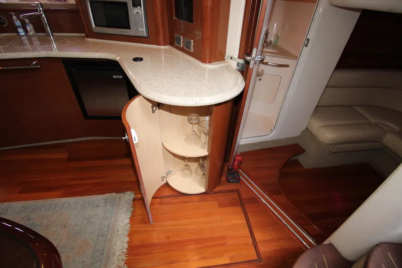 Rowdy Rio Yacht Photos Pics 2008 Sea Ray 44 Sundancer interior with open cabinet, wooden flooring, and modern kitchen amenities.