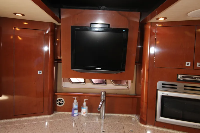 Rowdy Rio Yacht Photos Pics 2008 Sea Ray 44 Sundancer interior with TV, sink, and wooden cabinetry.