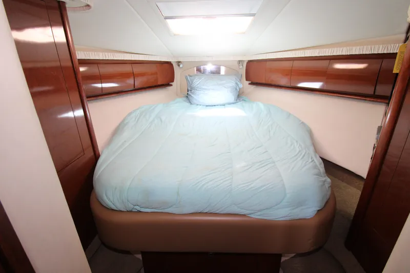 Rowdy Rio Yacht Photos Pics 2008 Sea Ray 44 Sundancer cabin with bed, wooden cabinets, and skylight.