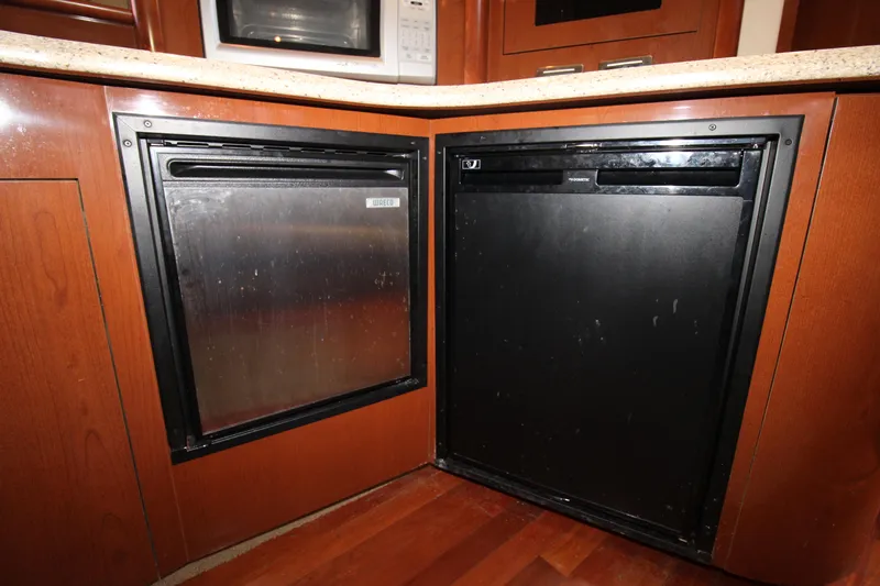 Rowdy Rio Yacht Photos Pics 2008 Sea Ray 44 Sundancer yacht kitchen with built-in appliances and wooden cabinetry.