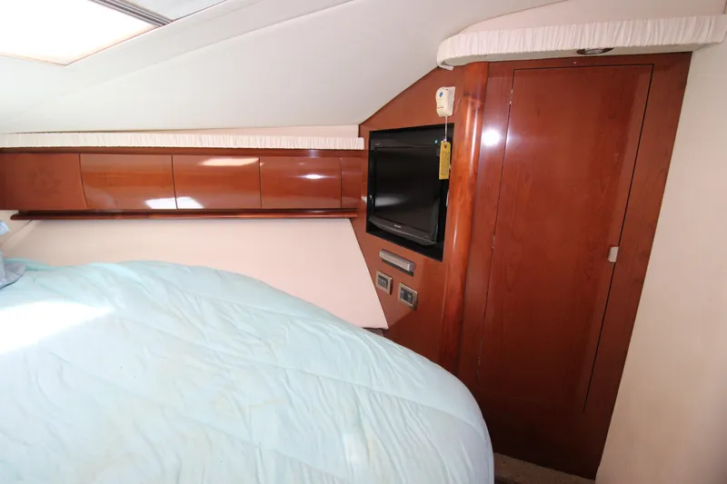 Rowdy Rio Yacht Photos Pics Interior cabin of 2008 Sea Ray 44 Sundancer with bed, TV, and wooden cabinetry.
