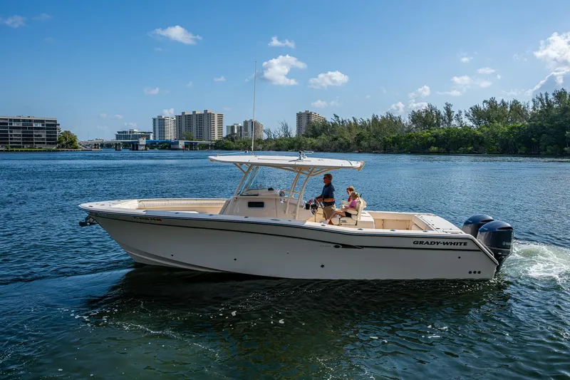  Yacht Photos Pics 2012 Grady-White 336 boat cruising on a sunny day near city skyline.