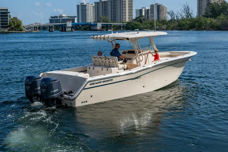  Yacht Photos Pics 2012 Grady-White 336 boat cruising on a sunny day near city buildings.