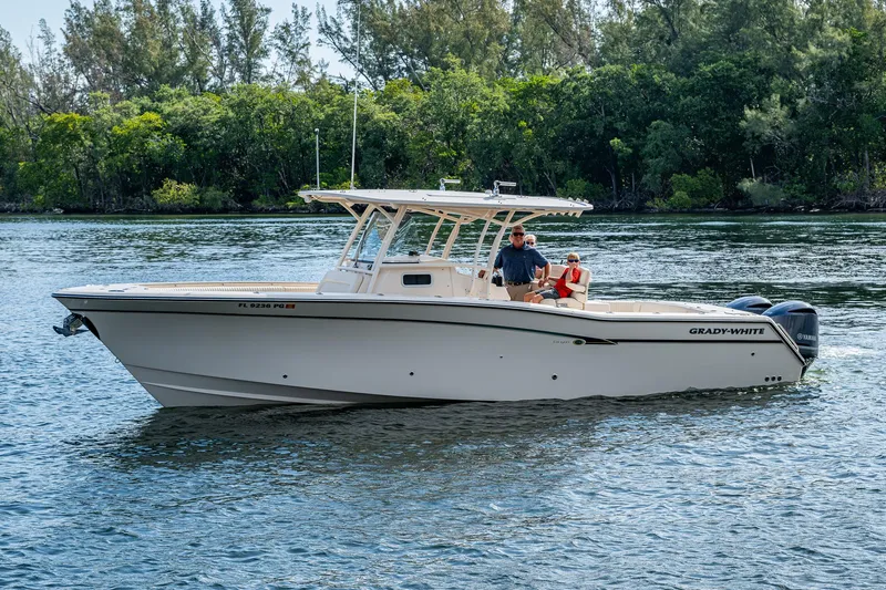  Yacht Photos Pics 2012 Grady-White 336 boat cruising on a calm river with lush greenery in the background.