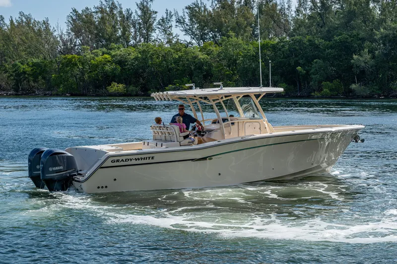  Yacht Photos Pics 2012 Grady-White 336 boat cruising on a scenic waterway with lush greenery.