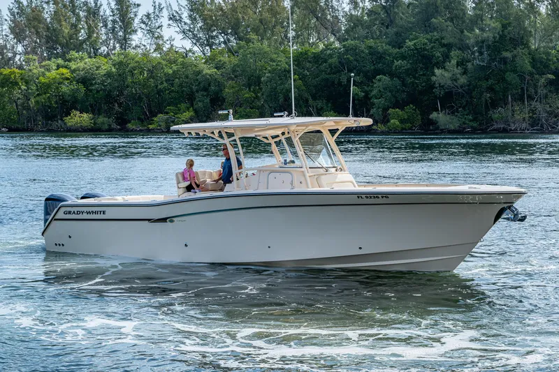  Yacht Photos Pics 2012 Grady-White 336 boat cruising on a scenic waterway with lush greenery.