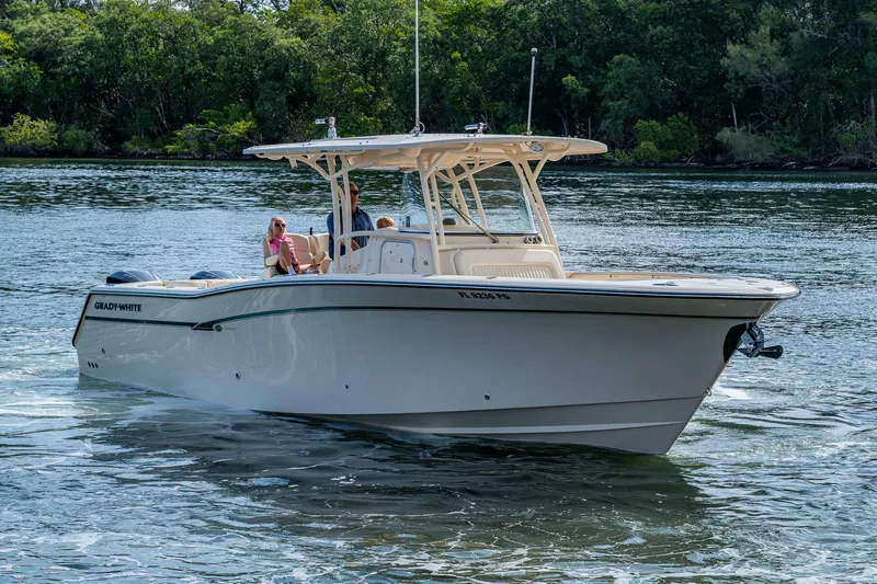 Yacht Photos Pics 2012 Grady-White 336 boat cruising on a calm river with lush greenery.