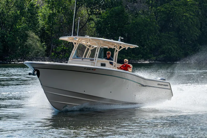  Yacht Photos Pics 2012 Grady-White 336 boat cruising on a river with lush greenery in the background.