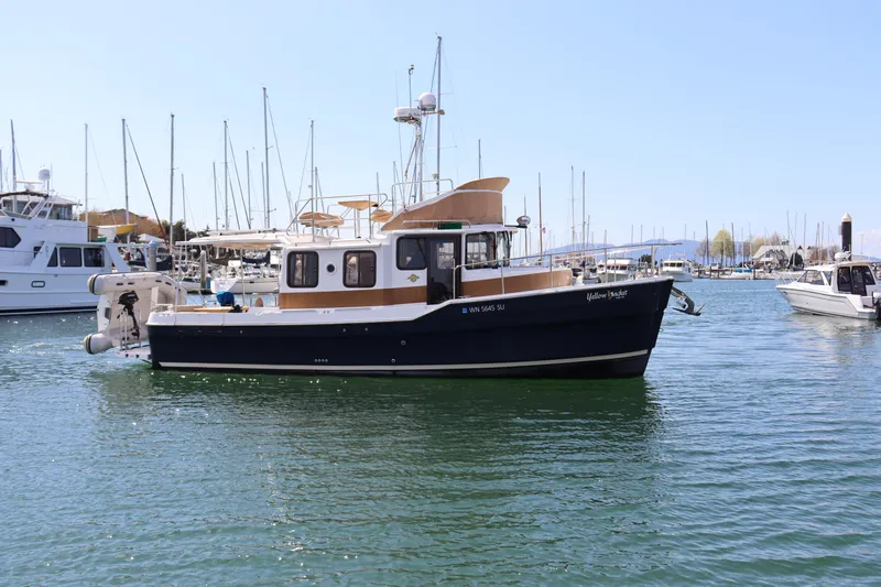 Yellow Jacket Yacht Photos Pics 2020 Ranger Tugs R-31 CB boat docked in a marina, surrounded by other vessels.