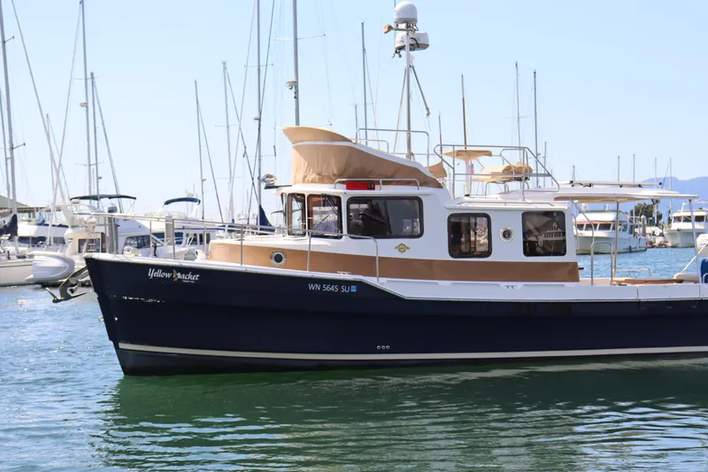 Yellow Jacket Yacht Photos Pics 2020 Ranger Tugs R-31 CB boat docked in marina, surrounded by sailboats.