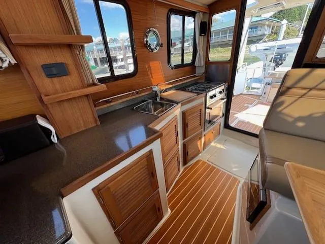 Yellow Jacket Yacht Photos Pics Interior of 2020 Ranger Tugs R-31 CB, featuring a compact kitchen with wood accents.