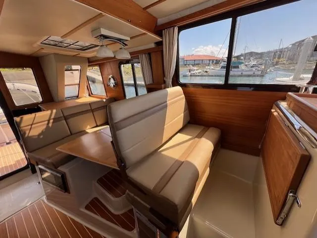 Yellow Jacket Yacht Photos Pics 2020 Ranger Tugs R-31 CB interior with seating, table, and marina view.