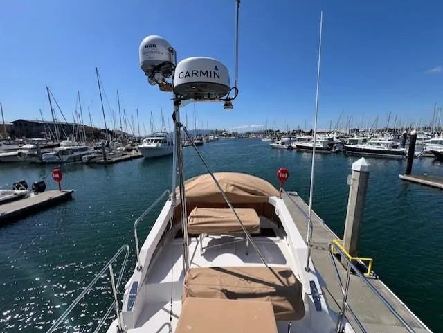 Yellow Jacket Yacht Photos Pics 2020 Ranger Tugs R-31 CB docked in a marina, surrounded by boats under a clear blue sky.