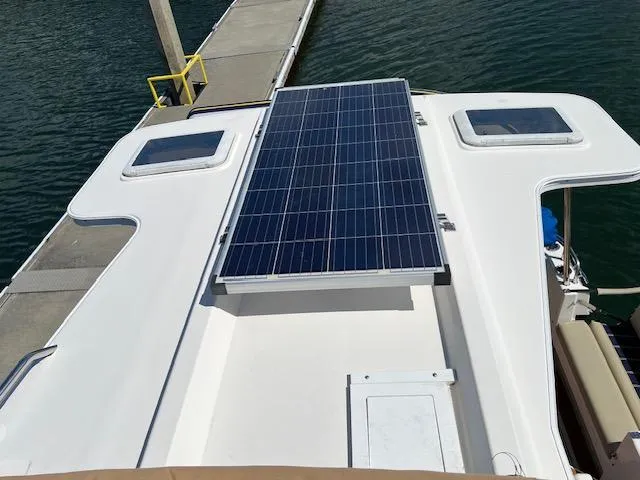 Yellow Jacket Yacht Photos Pics 2020 Ranger Tugs R-31 CB with solar panel on deck, docked by water.