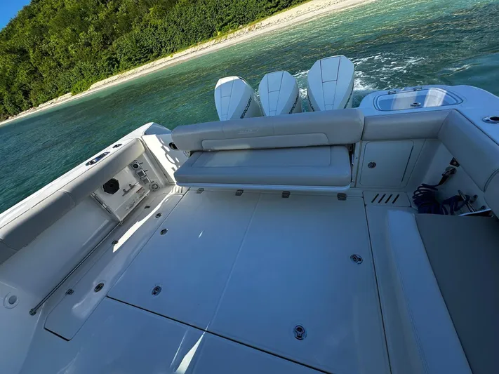  Yacht Photos Pics Boston Whaler 345 Conquest 2022 boat with triple engines near a sandy beach.