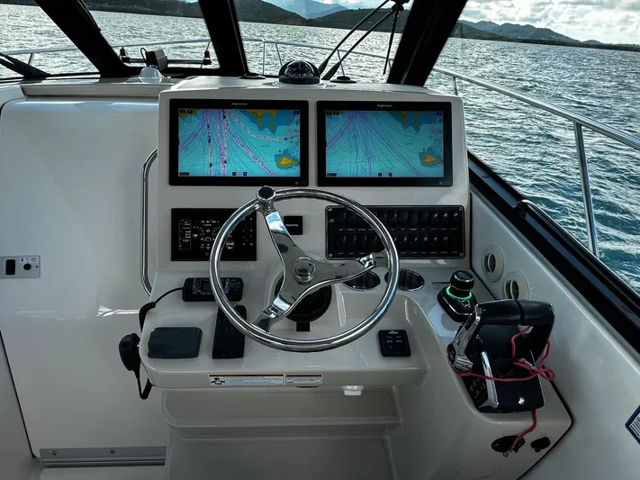  Yacht Photos Pics 2022 Boston Whaler 345 Conquest helm with dual navigation screens on open water.