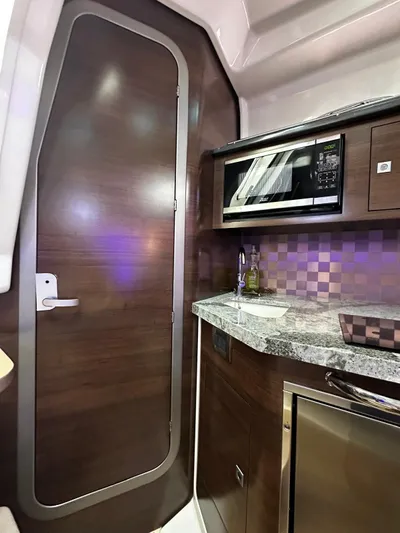  Yacht Photos Pics Interior of 2022 Boston Whaler 345 Conquest, featuring modern kitchenette with microwave and sleek cabinetry.