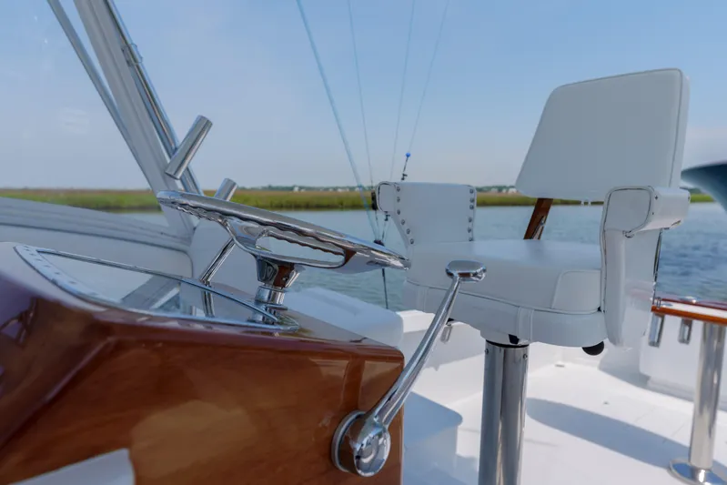 Enticer Yacht Photos Pics 1998 Gamefisherman Enticer helm with steering wheel and captain's chair on a sunny day.