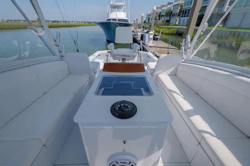 Enticer Yacht Photos Pics 1998 Gamefisherman Enticer boat interior with white seating and navigation equipment at a marina.