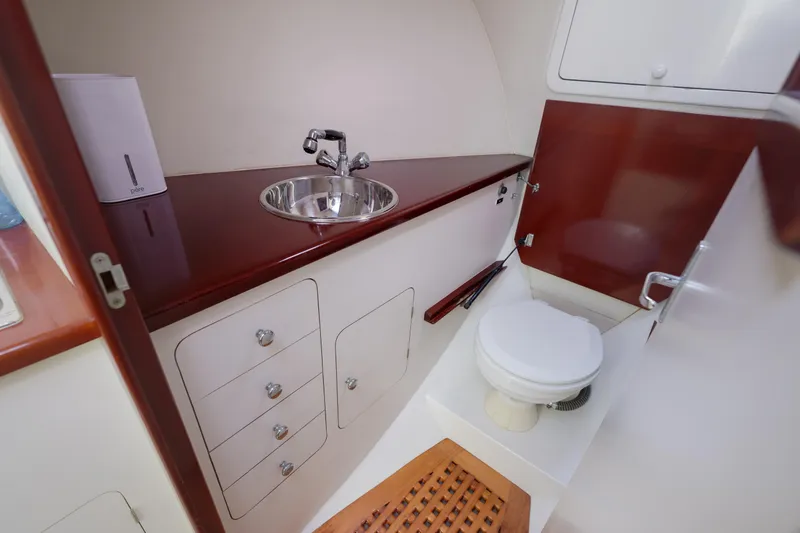 Enticer Yacht Photos Pics 1998 Gamefisherman Enticer boat bathroom with sink, toilet, and storage cabinets.