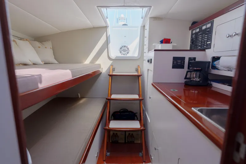 Enticer Yacht Photos Pics 1998 Gamefisherman Enticer cabin interior with bunk beds, kitchenette, and wooden stairs.