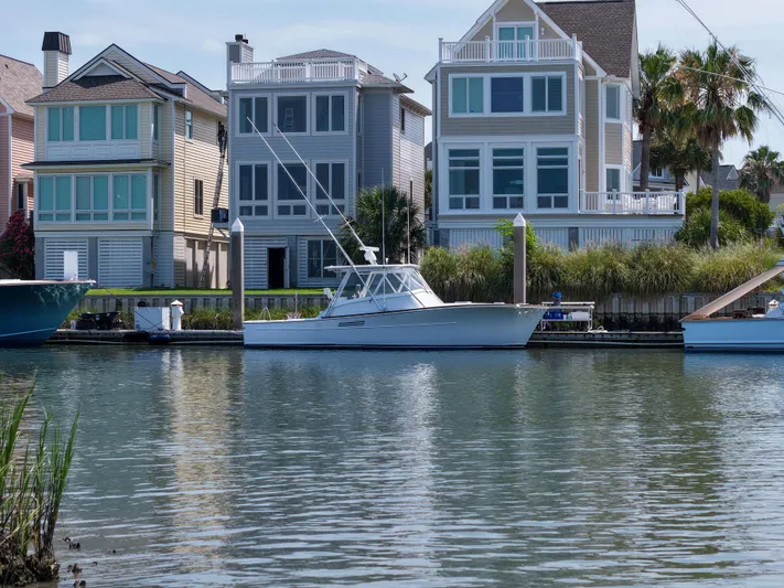 Enticer Yacht Photos Pics 1998 Gamefisherman Enticer boat docked near waterfront homes.