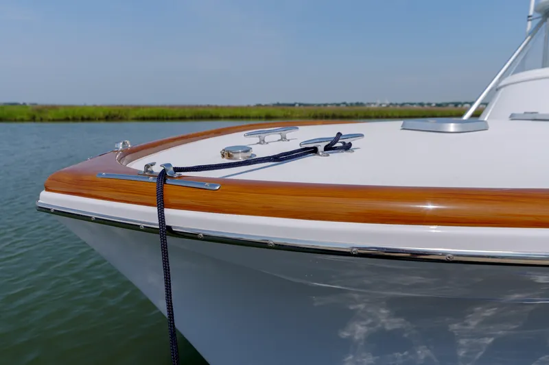 Enticer Yacht Photos Pics 1998 Gamefisherman Enticer boat bow with polished wood trim and mooring line on calm water.