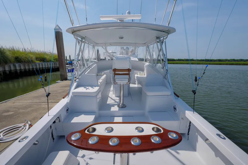 Enticer Yacht Photos Pics 1998 Gamefisherman Enticer boat interior with fishing rods, docked by calm waters.