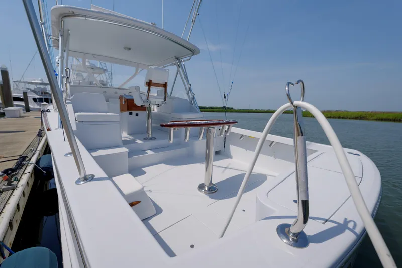 Enticer Yacht Photos Pics 1998 Gamefisherman Enticer boat docked, featuring spacious deck and seating area under clear sky.