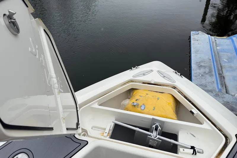  Yacht Photos Pics 2020 SeaVee 290B boat with open storage compartment near water.