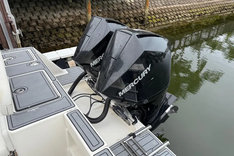  Yacht Photos Pics 2020 SeaVee 290B boat with dual Mercury outboard engines docked by a stone wall.