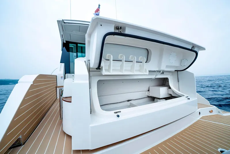  Yacht Photos Pics Manufacturer Provided Image: 2025 Tiara Yachts 48 LE with open storage compartment, docked on calm waters.