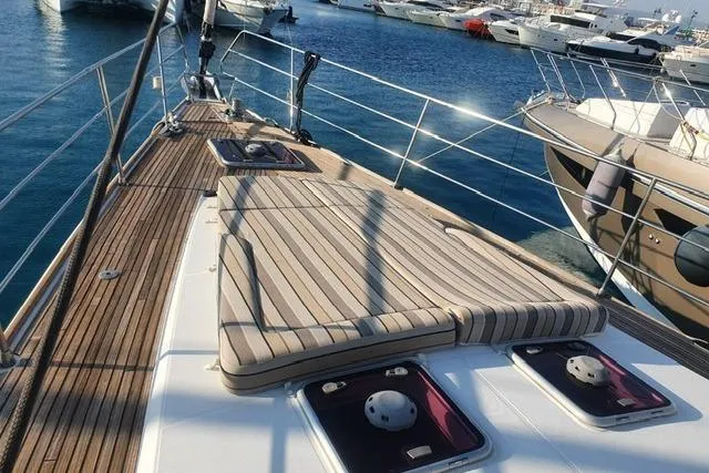  Yacht Photos Pics 2013 Jeanneau 57 yacht deck with sunbathing area, docked in a marina.