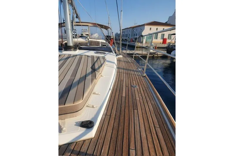  Yacht Photos Pics 2013 Jeanneau 57 yacht deck with wooden finish, docked in a marina.