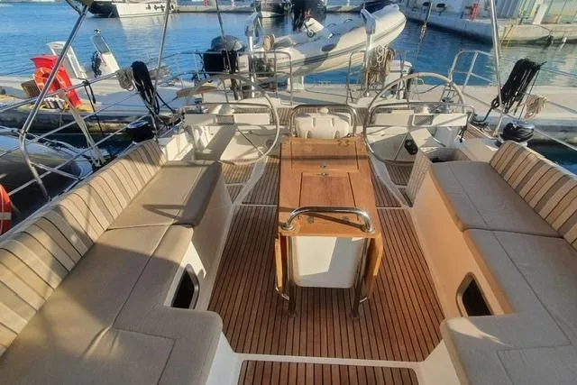  Yacht Photos Pics Spacious deck of a 2013 Jeanneau 57 yacht with elegant seating and wooden table.