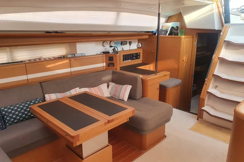  Yacht Photos Pics Luxurious interior of a 2013 Jeanneau 57 yacht with cozy seating and elegant wood finishes.