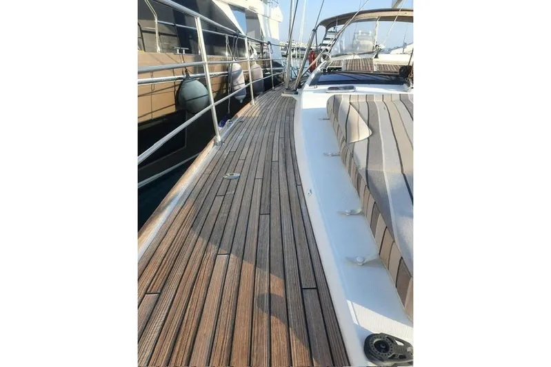 Yacht Photos Pics 2013 Jeanneau 57 yacht deck with wooden flooring and striped seating.